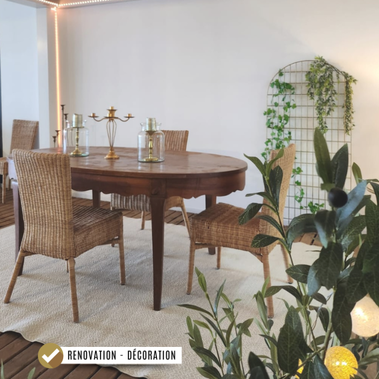 Décoration et rénovation à Dijon Table en bois avec des chaises en osier, décorée de plantes vertes, sous une pergola bioclimatique