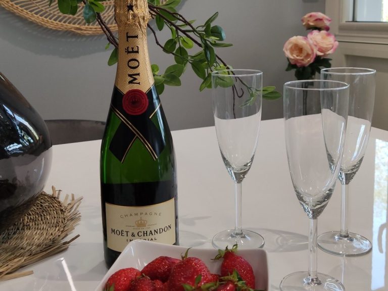 aménagement intérieur Champagne, coupes à champagne, fraises fraîches sur une table avec des fleurs en arrière-plan.