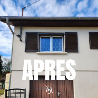 Nos volets solaires Façade d'une maison avec fenêtres à volets, portail en bois et ciel nuageux.